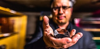 Colorado College professer Steven Hayward holds prism from a long lost telescope on his quest to find the artifact ahead of the full solar eclipse