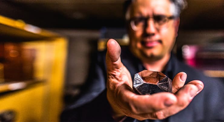 Colorado College professer Steven Hayward holds prism from a long lost telescope on his quest to find the artifact ahead of the full solar eclipse