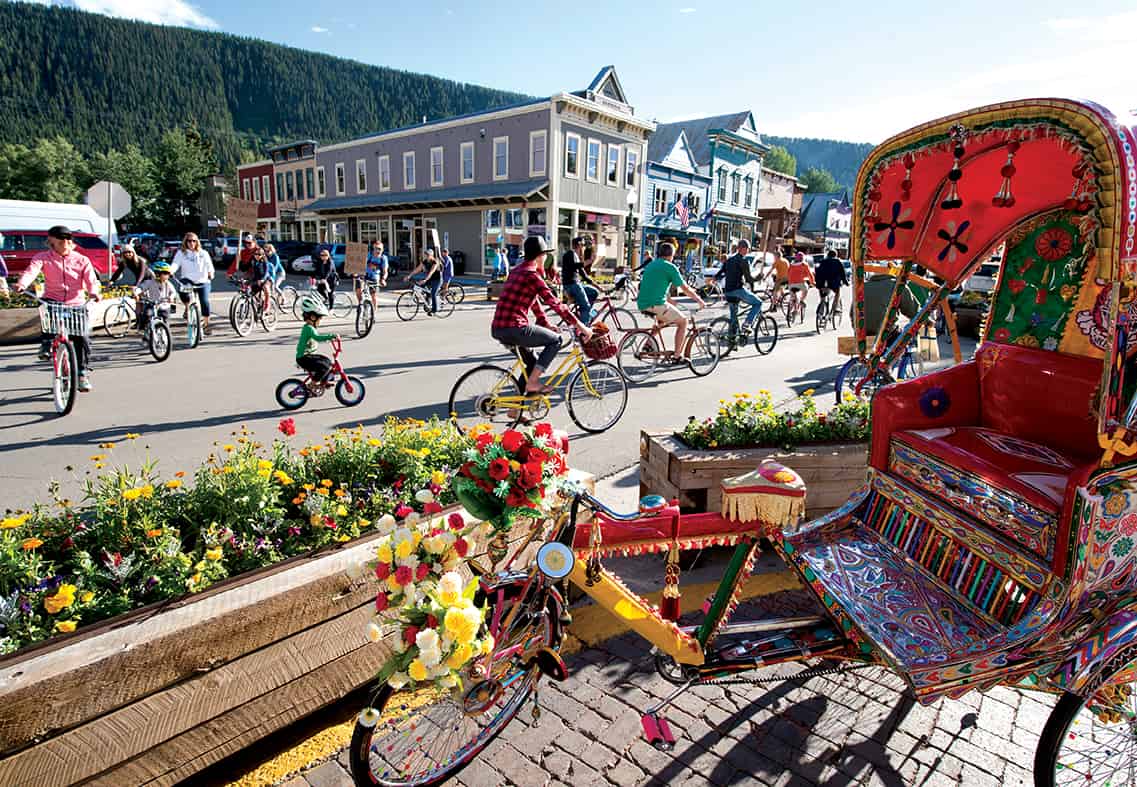 A bike parade on Elk Avenue, Crested Butte as seen from the patio of Secret Stash pizza restaurant.