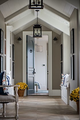 Inside view of a tall front door flanked by flowerpots