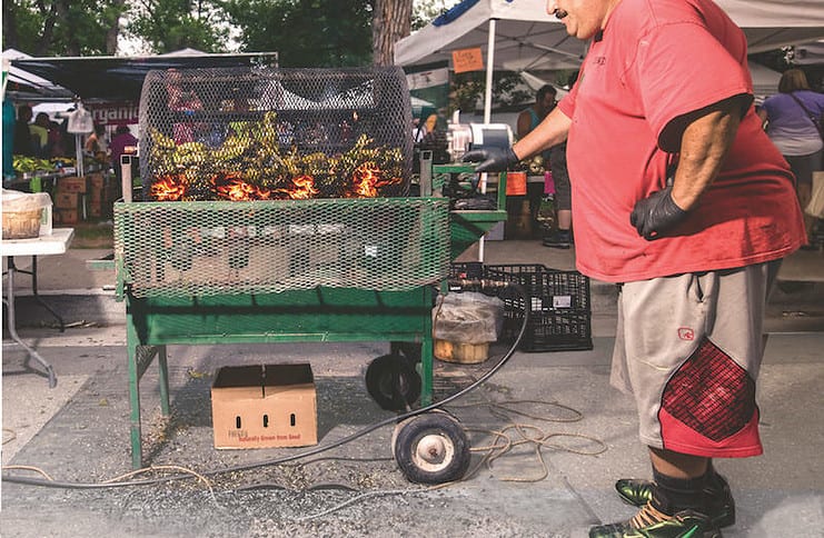 A large man roasting Pueblo chiles at the Pueblo Chile and Frijoles Festival in Pueblo, Colorado.