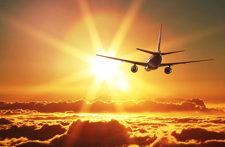 airfare airplane flies into sunset