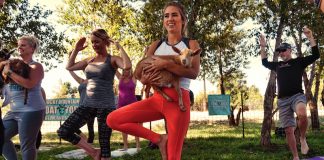 Girl in yoga pose holding a goat. Rocky Mountain Goat Yoga is one of the best things to do in Colorado Springs this weekend.