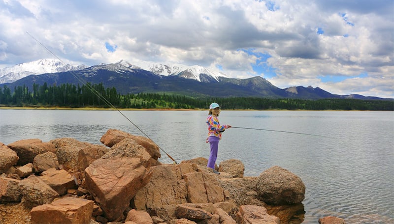 A girl fishing at Catamount Reservoir in the North Slope Recreation Area on Pikes Peak