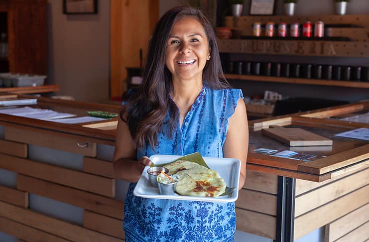owner Monse Hines serves Pupusas at Monse's Taste of El Salvador