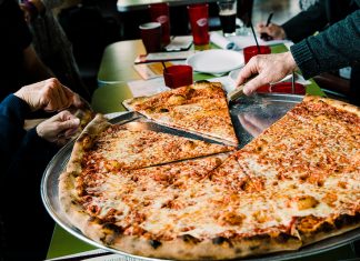 Best New York Style Pizza Restaurants in Colorado Springs Serving a slice from a huge Fat Sully's New York Pizza