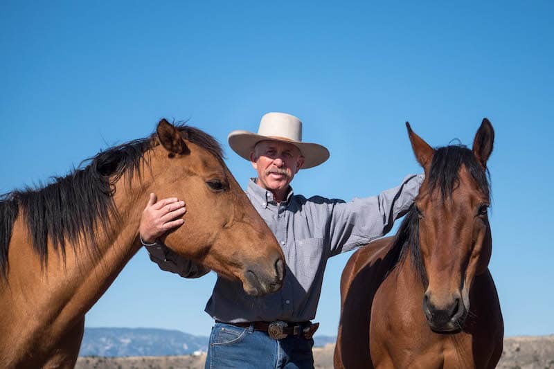 Tom Hirt with horses and cowboy hat