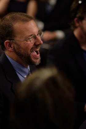Man laughing at a gathering
