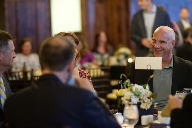 Scene of people seated at tables in a gathering
