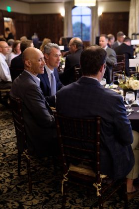 Seated men at a table, talking