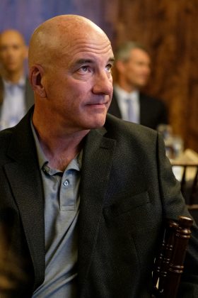 A man at a gathering looking into the distance