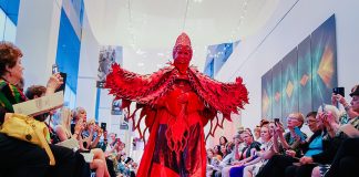 A person in a red costume walks the runway at Sashay, a fashion event at the Colorado Springs Fine Arts Center at Colorado College to celebrate the World of Wearable Art exhibition.