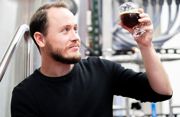 Charles McManus, head brewer at Phantom Canyon holds up a glass of beer