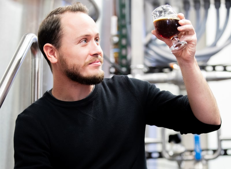Charles McManus, head brewer at Phantom Canyon holds up a glass of beer