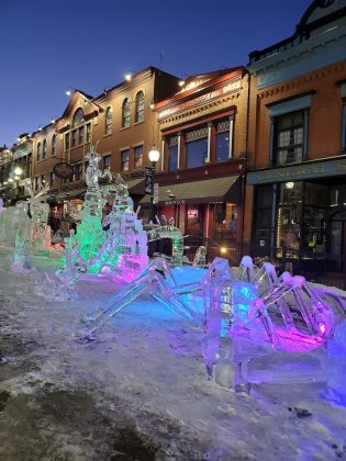 A parade of giant insects. carved from ice.