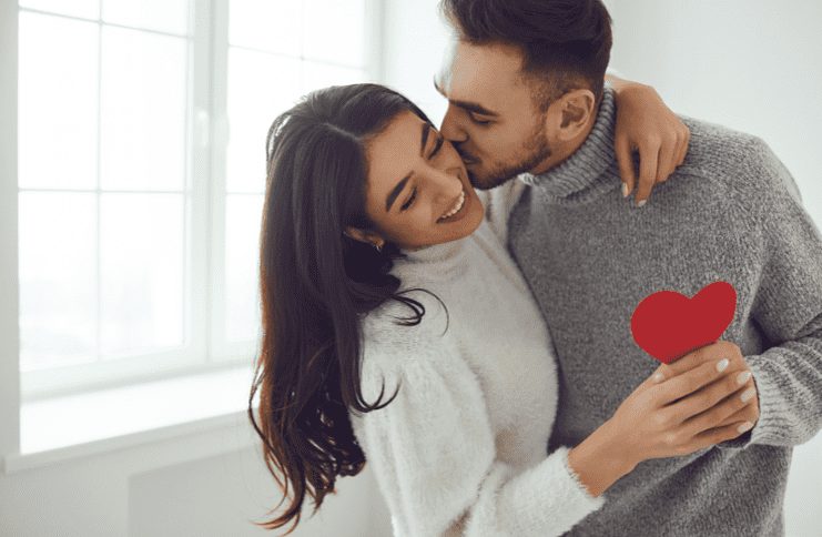 couple kissing with red heart cut-out for valentine's day in colorado springs