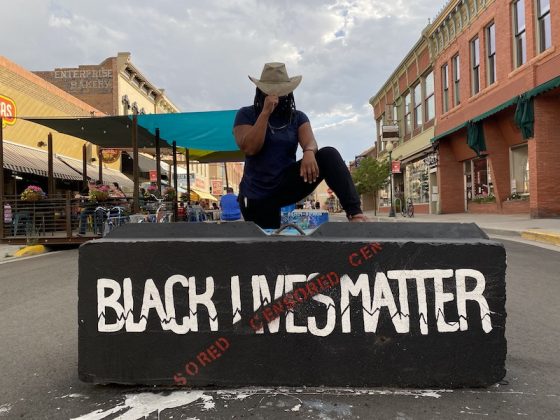 Patricia Cameron kneeling on a Black Lives Matter block