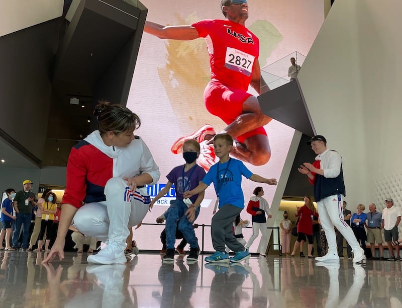 Kids run with athletes inside the US Olympic & Paralympic Museum