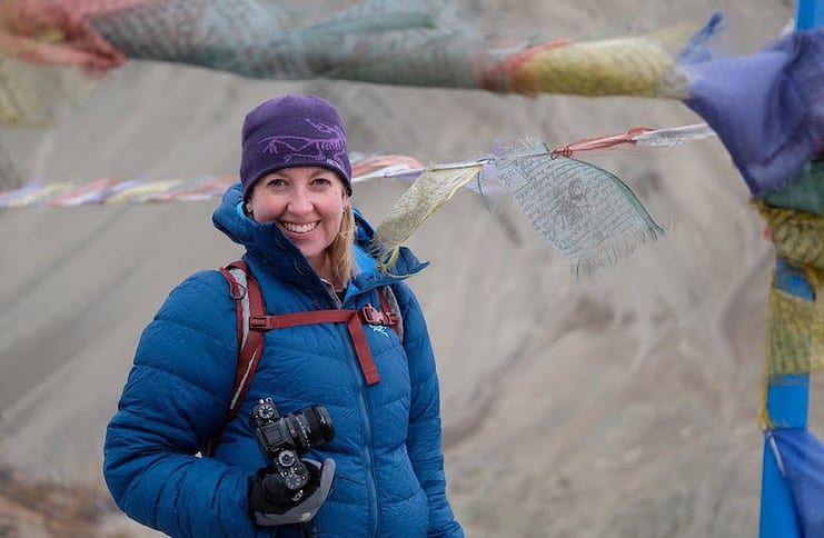 Rebecca Jewett of Palmer Land Conservancy hikes with Buddhist prayer flags in the background