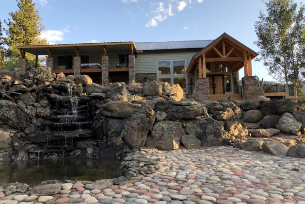 A stone path and water fall dress the cabin's exterior.