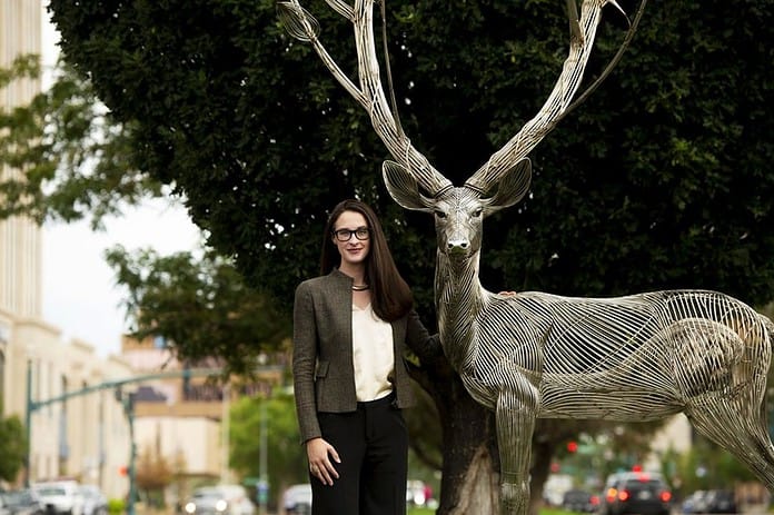 swinford-headshot_chauncey-bus Claire Swinford headshot next to a stag statue