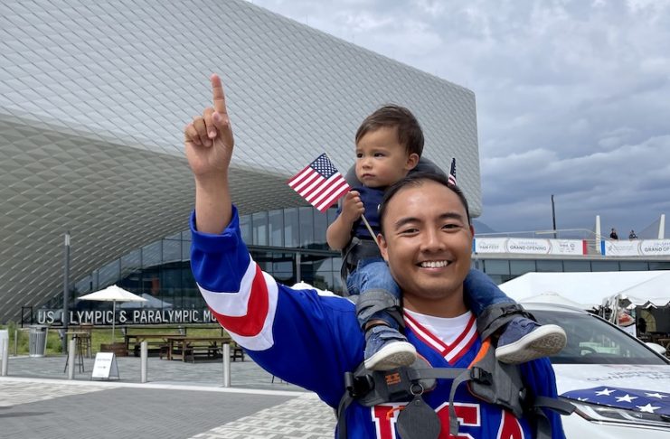man and son on his shoulders standing in front of the US Olympic and Paralympic museum to celebrate the olympics