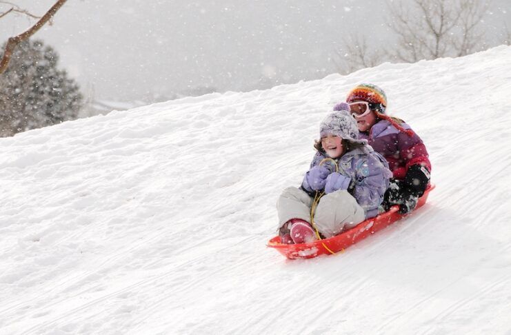 Two girls sledding at Bear Creek Park in Colorado Springs
