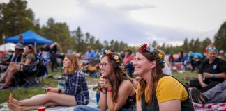 women sitting on a blanket outside at the meadowgrass music festival, of the best annual Colorado Springs events