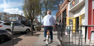 Andy Vick riding around town on a bike