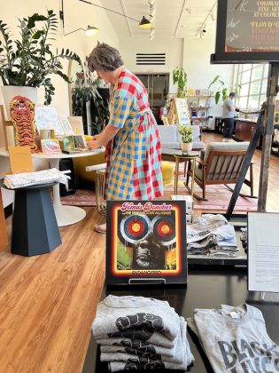 Morgan Calderini tends the gift shop at the Fine Arts Center, curated by Ladyfingers Letterpress.