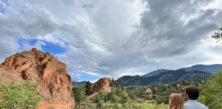 Couple standing beside lake and cliffs at Red Rock Open Space near Manitou Springs