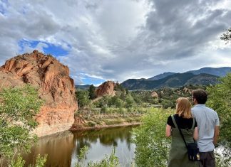 The Westside Is the Best Side Couple standing beside lake and cliffs at Red Rock Open Space near Manitou Springs