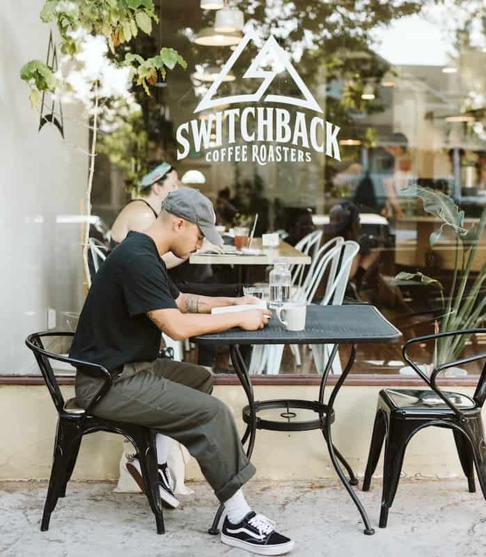 Man enjoys coffee in front of Switchback Coffee Roasters in downtown Colorado Springs