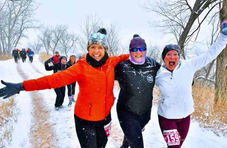Three women run in the snow at the Rescue Run, a fun holiday workout in Colorado Springs and one of the best things to do this weekend.