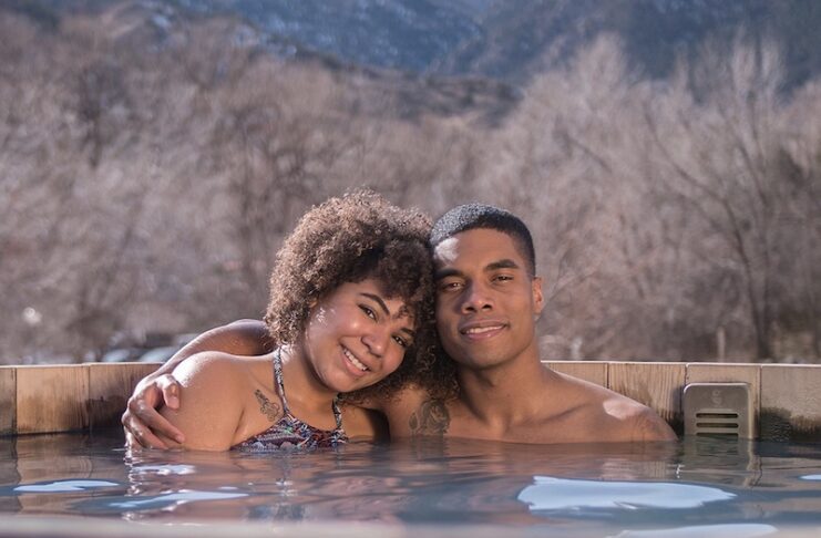 Couple soaking in a hot spring pool at SunWater Spa, a great date night idea in Colorado Springs