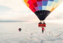 A man walks a slackline between hot air balloons in Walking on Clouds, a film screening at the Banff Mountain Film Festival, one of three outdoor film festivals happening during March.