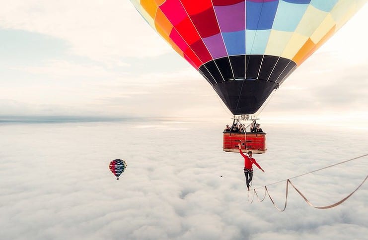 A man walks a slackline between hot air balloons in Walking on Clouds, a film screening at the Banff Mountain Film Festival, one of three outdoor film festivals happening during March.