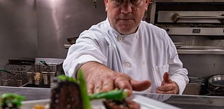 Chef James Africano serves a dish from the open kitchen at The Warehouse in Colorado Springs.