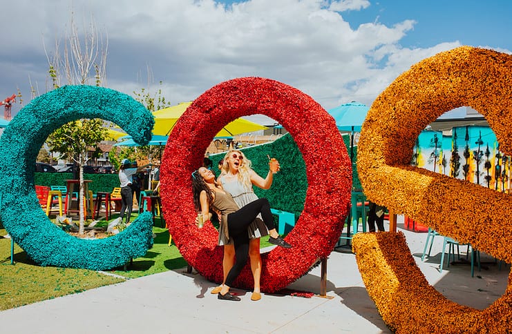 Posing in front of the COS sign at the festive new patio bar Colorful Colorado at the Garden in Colorado Springs.