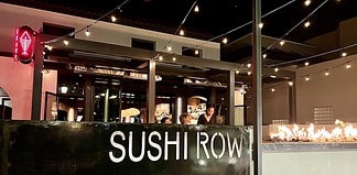 String lights and a fire pit illuminate the front of Sushi Row restaurant in Colorado Springs