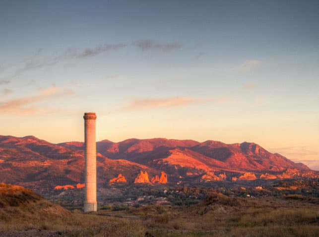 The historic smokestack at Gold Hill Mesa with Garden of the Gods and Rampart Range at sunset in the background. The site is the future home of a Gold Hill Mesa amphitheater.