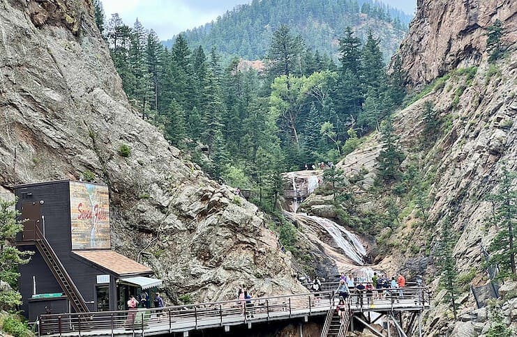 The upper waterfalls of the Broadmoor Seven Falls in Colorado Springs with the Eagles Nest viewing platform in the foreground.