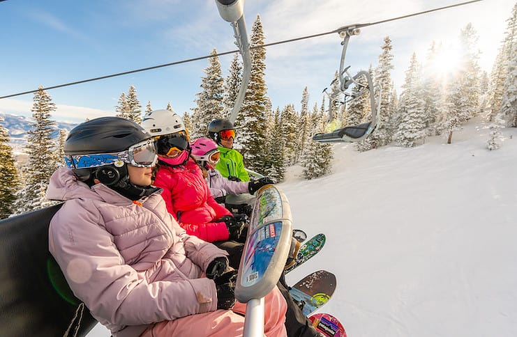 A family rides a chairlift at Aspen Snowmass