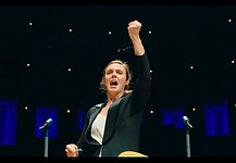 A woman conducts an orchestra in a still photo from the documentary film Maestra.
