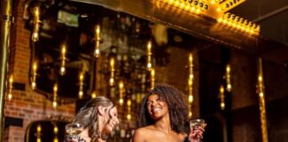Two women celebrate with champagne in the lobby of the Mining Exchange Hotel for New Year's Eve.