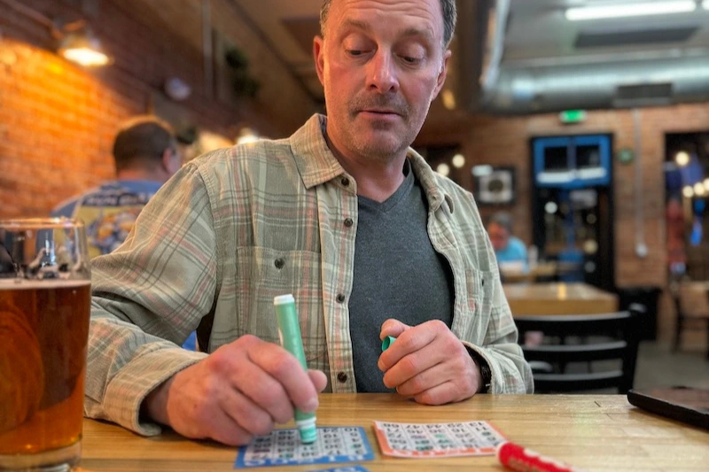 Man filling out his bingo card at Mash Mechanix.