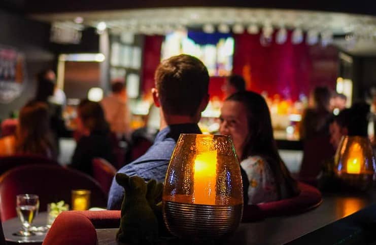 A couple enjoys the moody lighting and a romantic date night at Tokki