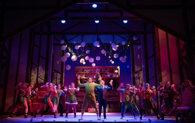 Cast of Elf dances on stage at the Fine Arts Center Theatre, one of the biggest live theaters in Colorado Springs.
