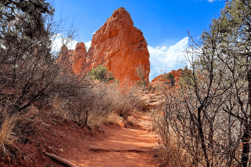 A hiking trail and red rock tower at Garden of the Gods in Colorado Springs, one of the best free things to do in the city.