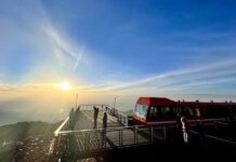People take photos from the observation deck of sunrise on Pikes Peak at the Pikes Peak Summit Visitor Center.